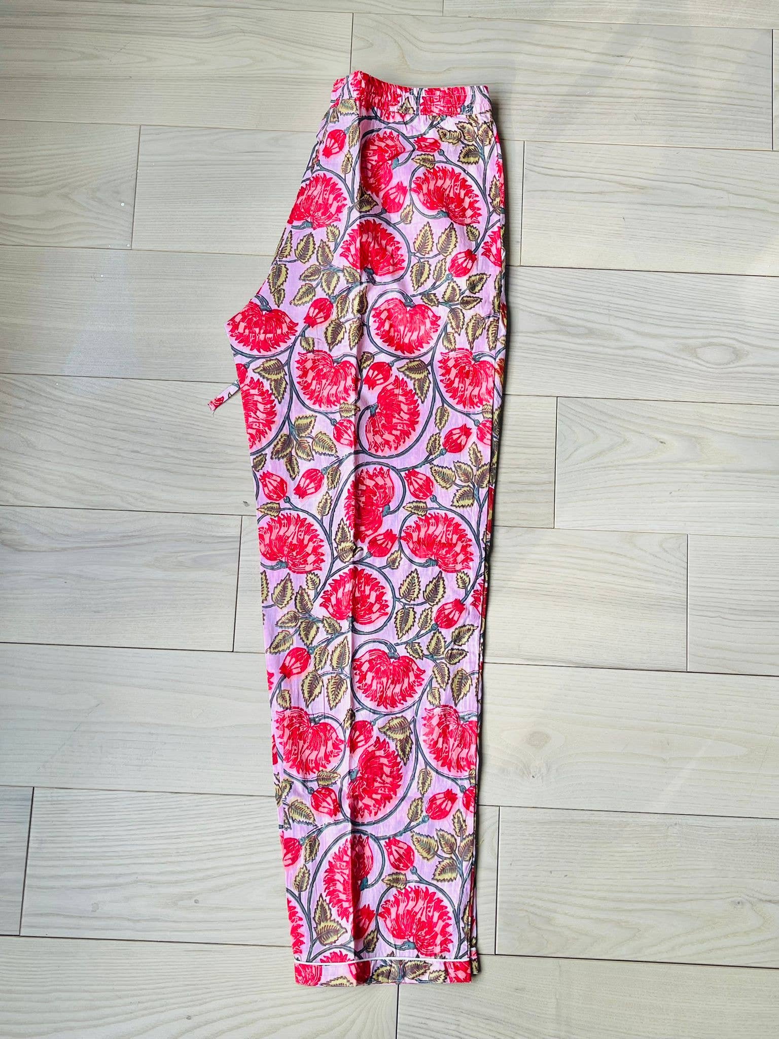 A pink and red floral hand-block printed 100% cotton pajama set with a button-down top and matching pants.