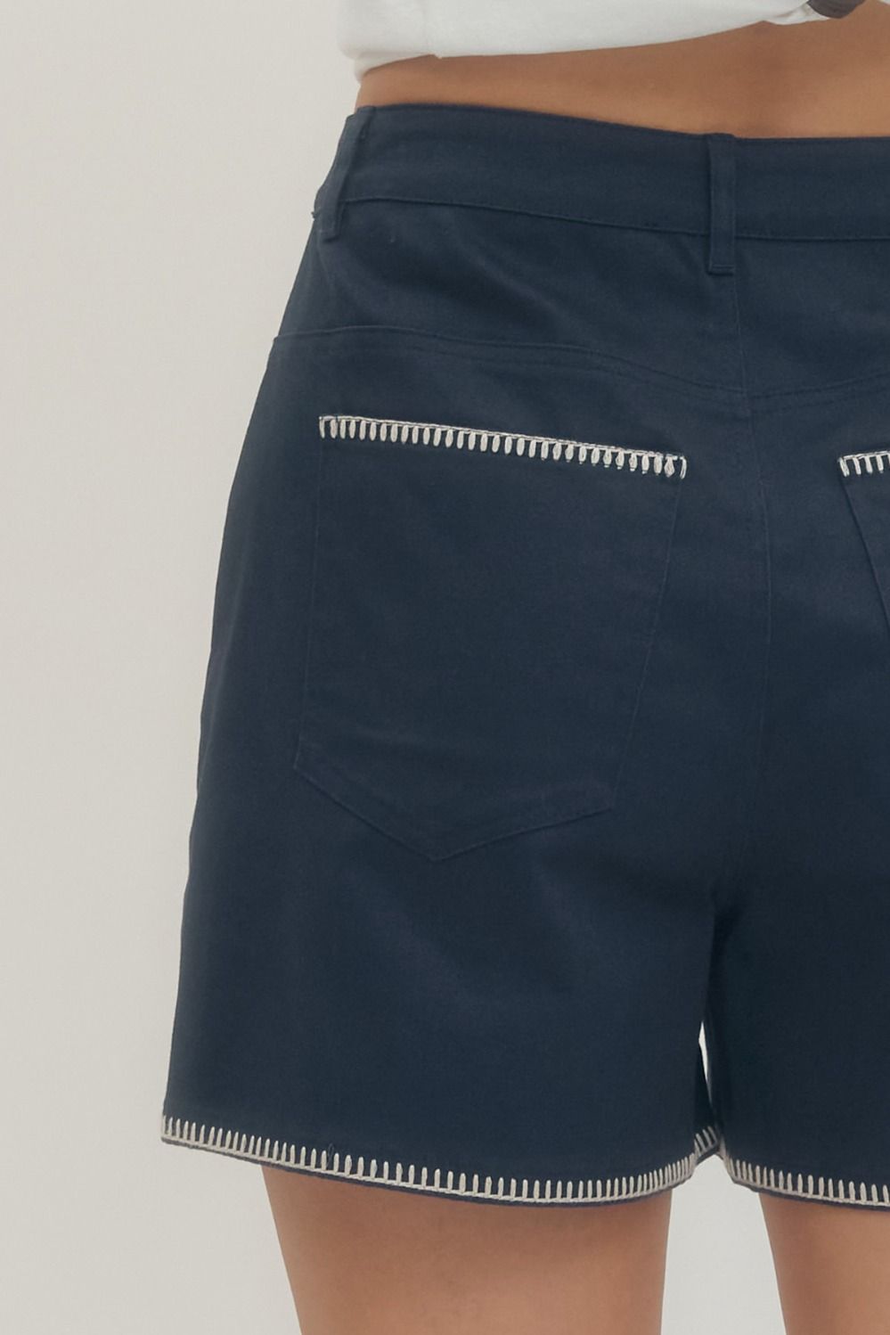 Navy shorts with white trim on a neutral background