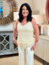 Smiling woman with dark hair modeling a cream 100% cotton sleeveless tank top with a crochet knit front design.