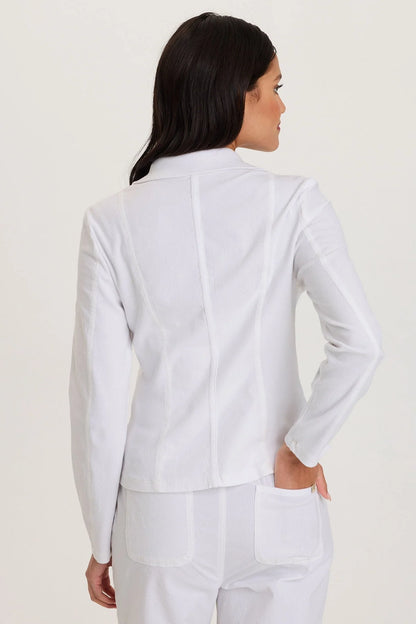 Rear view of a woman wearing a structured white cotton fleece zip-up jacket with front pockets and a cozy mock neckline.