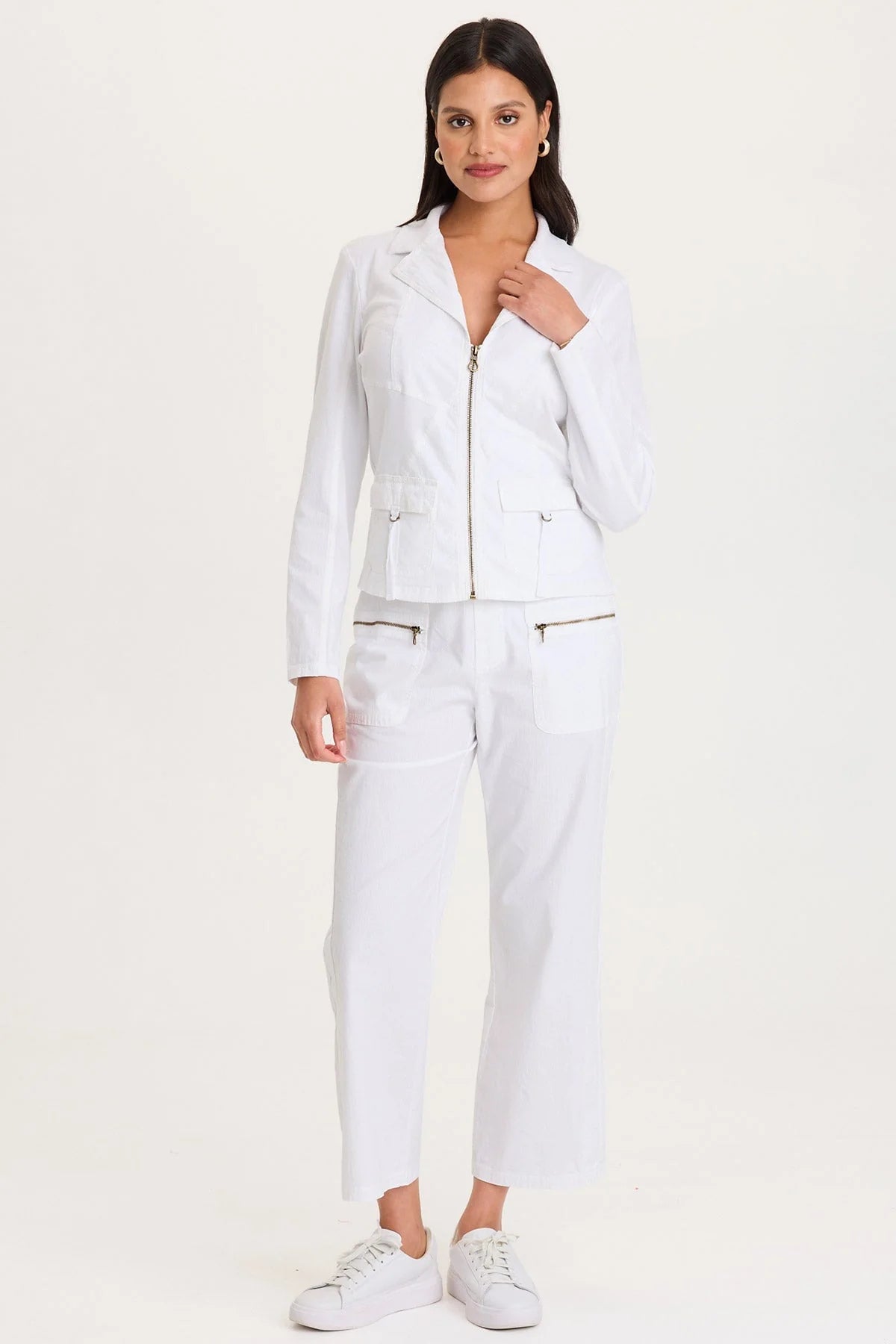 Full body view of a woman wearing a white outfit with a jacket and pants on a white background