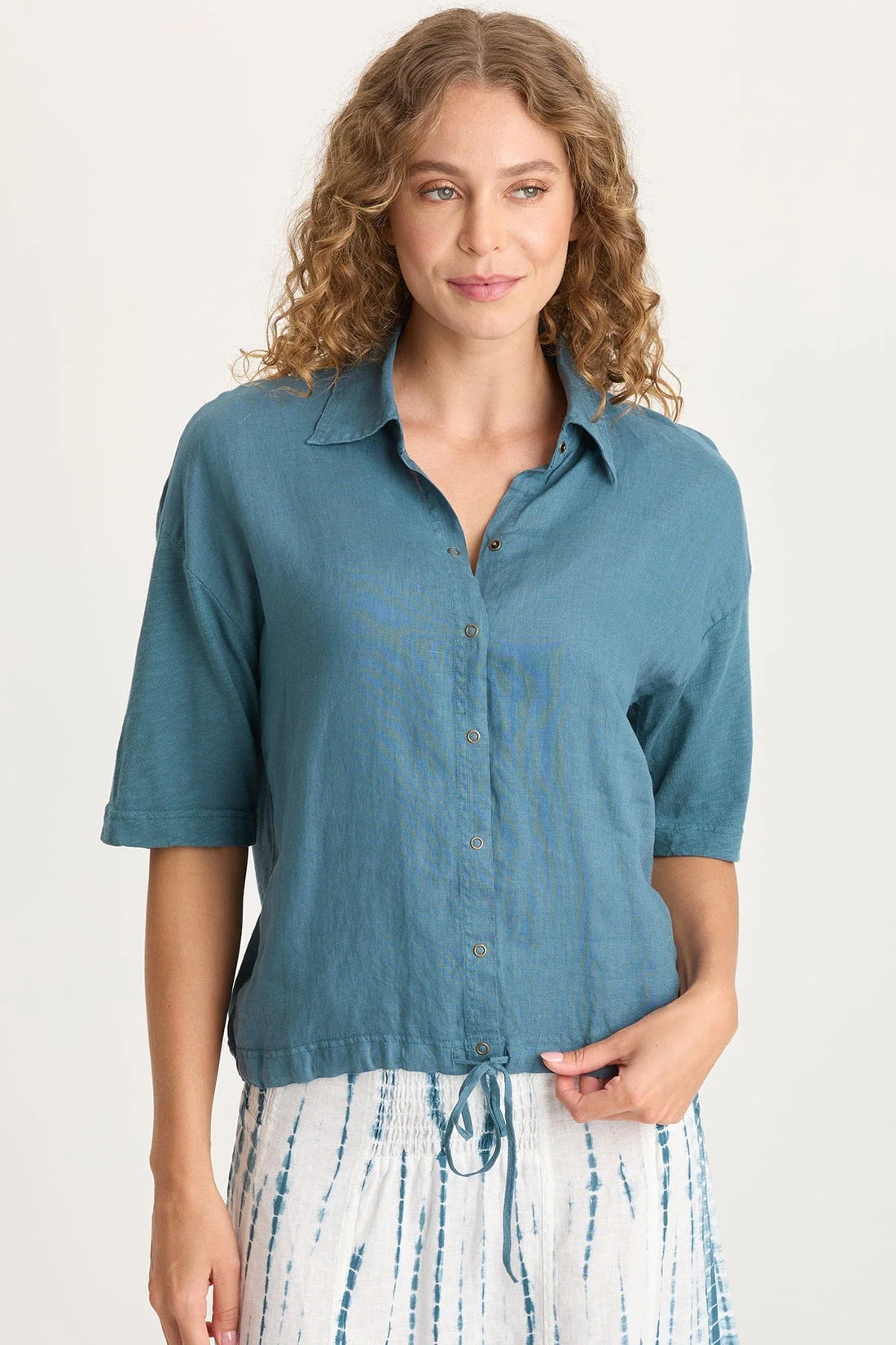 Woman wearing a blue denim shirt with a white background