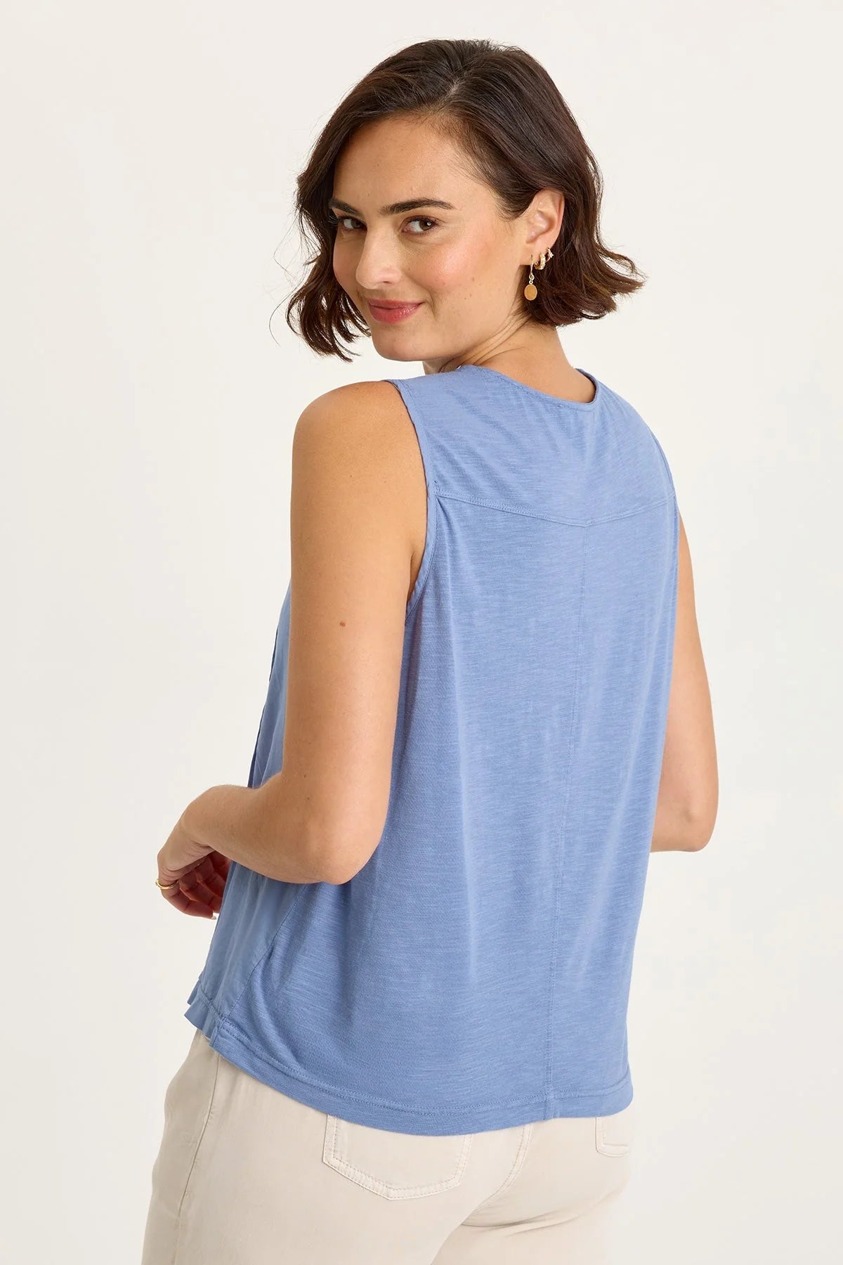 Rear view of woman wearing a blue sleeveless top on a white background