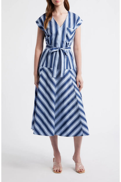 A woman wearing a blue and white multi-directional striped midi dress with a V-neckline, short cap sleeves, and a matching fabric tie belt.