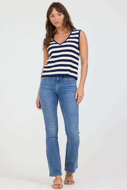 Full size view of a woman wearing a striped tank top and blue jeans on a white background