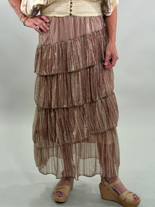 Close up of a woman wearing a layered, patterned skirt on a plain background