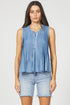 A woman wearing the sleeveless pleated Tencel tank top in denim blue with light-wash denim shorts