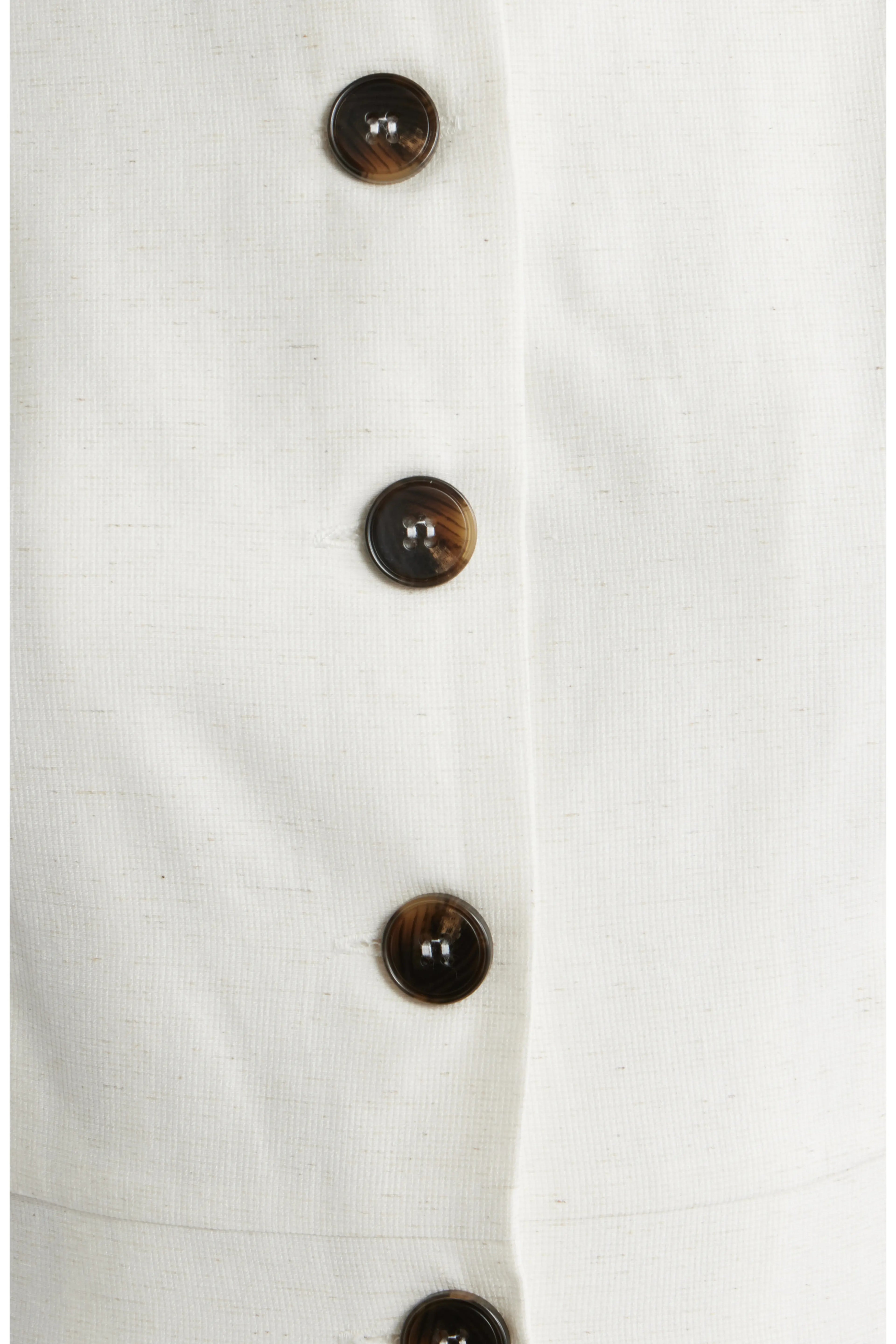 Close up of oatmeal colored dress with brown buttons.