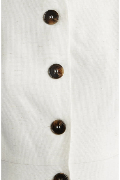Close up of oatmeal colored dress with brown buttons.