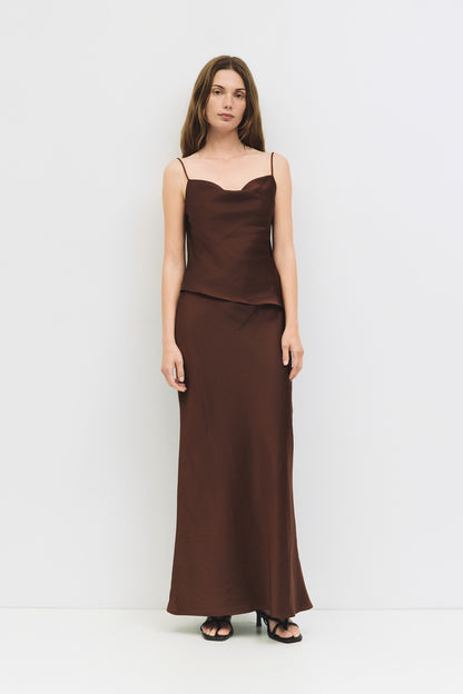 Full body view of a woman wearing a chocolate brown satin cowl neck tank.