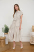 Woman wearing a light taupe and cream vertically striped midi shirt dress with a tie belt, short cap sleeves, and high heels.