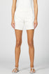 Front view of a woman wearing off-white mid-low rise casual shorts with a clean hem and white sandals.