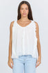 Front view of a woman wearing a flowy white sleeveless scoop-neck top with vertical ruffles and light blue jeans.