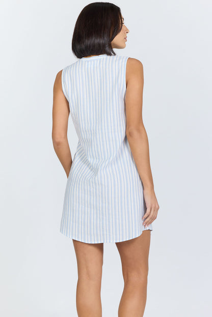 Rear view of a woman with a dark bob haircut wearing a sleeveless blue and white striped cotton mini dress with a button-front neckline.