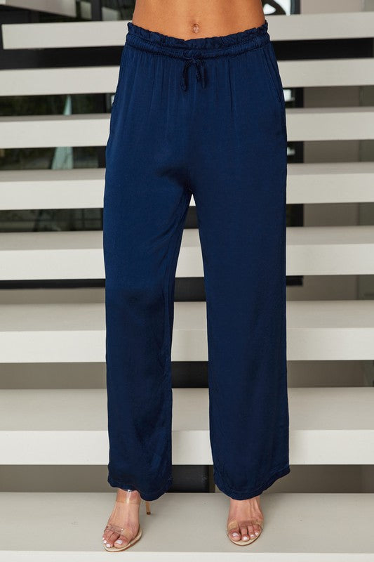 Navy blue pants worn by a person standing against a stairwell.