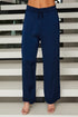 Navy blue pants worn by a person standing against a stairwell.