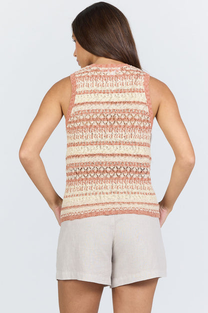 Rear view of a woman wearing a sleeveless crew-neck sweater tank with terra-cotta and ivory horizontal stripes, paired with light linen shorts.