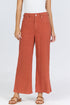 Front view of a woman wearing terracotta-colored high-rise wide-leg linen-blend pants with tan slide sandals.