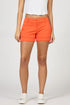 Front view of a woman wearing bright orange garment-dyed stretch shorts with a cuffed hem and white sneakers.