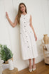 A woman wearing a sleeveless, button-front white midi dress with faux hip pockets and low heels.