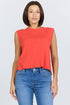 Woman wearing a poppy red sleeveless crew neck muscle tank made from textured slub cotton, paired with blue jeans.